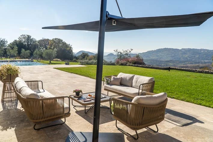Het terras bij het zwembad met design meubelen en een prachtig uitzicht